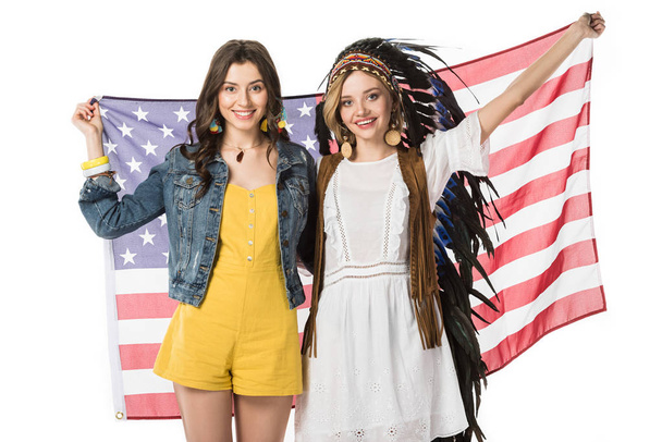 two smiling bisexual hippie girls holding american flag isolated on white - Photo, Image