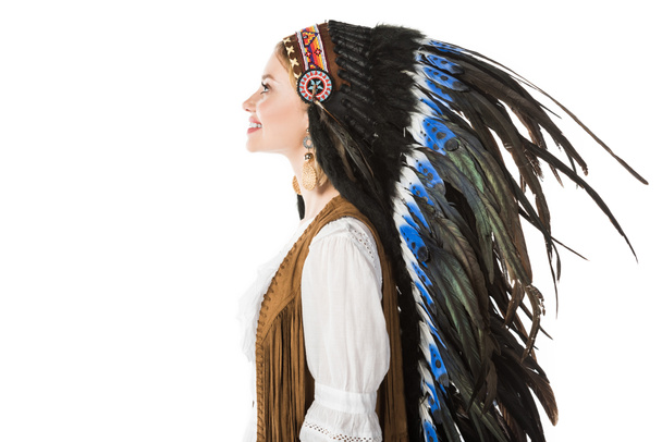 side view of smiling pretty boho girl in indian headdress isolated on white - Фото, изображение