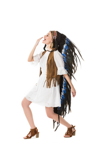 full length view of hippie girl in indian headdress dancing isolated on white - Photo, Image