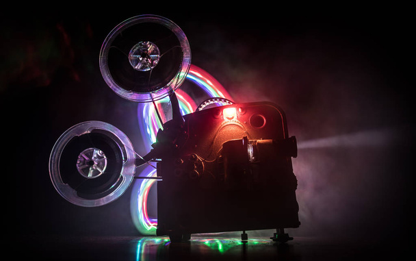 Starý filmový projektor na tmavém pozadí s mlhou a světlem. Koncepce tvorby filmů. - Fotografie, Obrázek