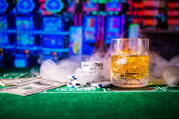 szerencsejáték, szerencse, játék- és szórakoztató koncepció - közelről kaszinó zseton és whisky-üveg asztal - Fotó, kép