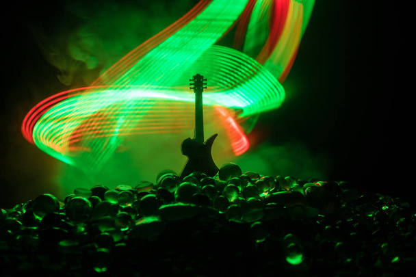Концепция музыки. Акустическая гитара изолирована на тёмном фоне под лучом света с дымом с копировальным пространством. Гитарные струны, закройте. Выборочный фокус. Пожарные. Сюрреалистичная гитара
 - Фото, изображение