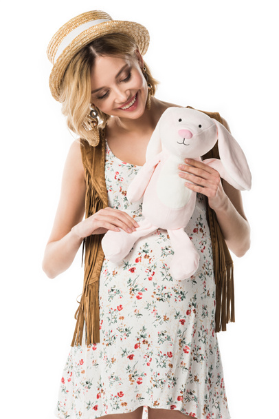 sorridente donna hippie incinta in possesso di coniglio giocattolo isolato su bianco
 - Foto, immagini