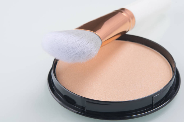 close-up of light powder for even makeup and brush on white background - Foto, afbeelding