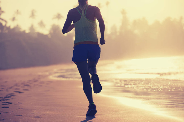 joven mujer fitness corriendo al amanecer en la playa
  - Foto, Imagen