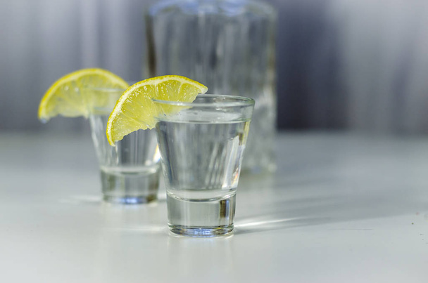 wodka in een glas met citroen - Foto, afbeelding