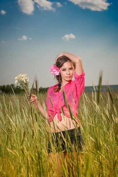 Young girl on golden wheat field.Portrait of beautiful blonde girl with wreath of wild flowers.Beautiful woman enjoying daisy field, pretty girl relaxing outdoor, harmony concept. - Foto, Bild