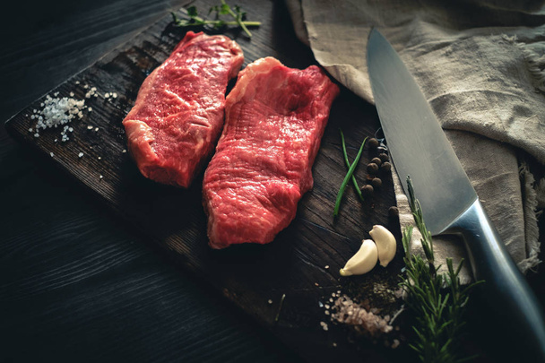 Two raw meat steak on a wooden Board on a table - Fotoğraf, Görsel