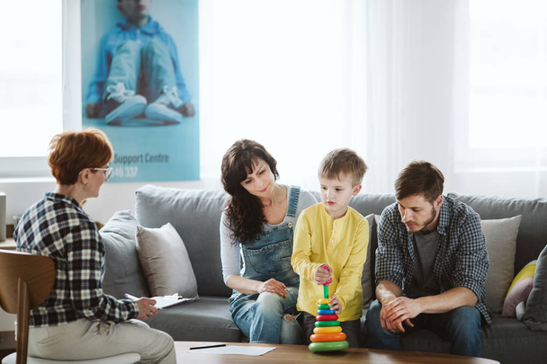 Parents and therapist are sitting on the couch during a meeting about their child - Foto, immagini