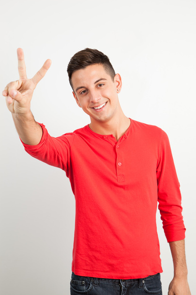 Young and handsome guy doing a peace sign - Photo, Image