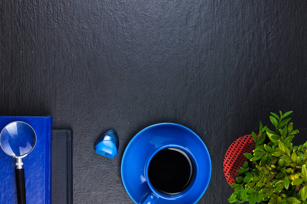 Black Office desk table with computer, pen and a cup of coffee, lot of things. Top view with copy space. - 写真・画像