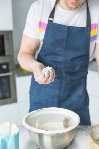 ręce przesiewające mąkę przez sito w żelaznej misce - Zdjęcie, obraz