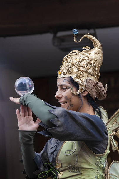mulher caracterizada como fada brincando com uma bola de cristal
 - Foto, Imagem