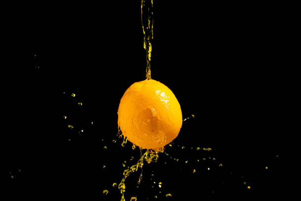 orange splash on black background - Фото, изображение