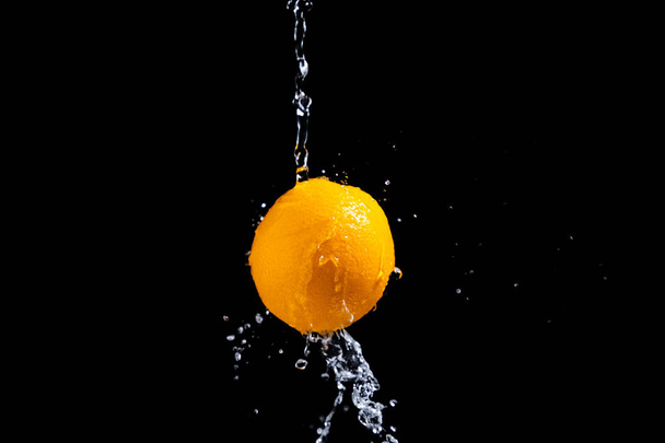 orange splash on black background - Valokuva, kuva