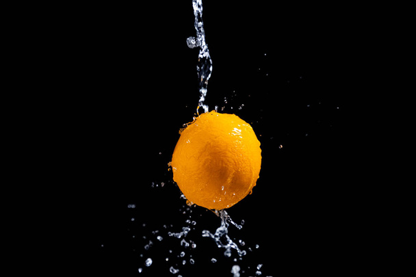 orange splash on black background - Foto, Imagen