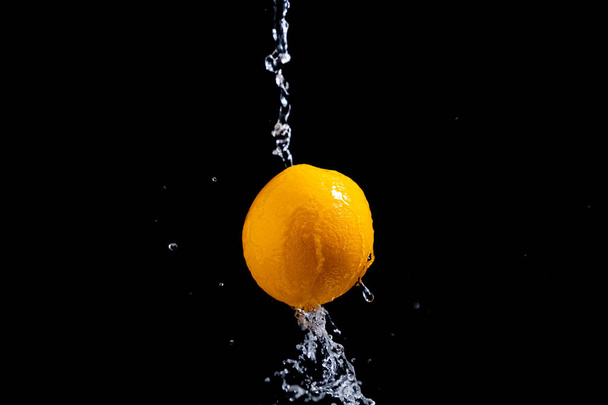 orange splash on black background - Foto, Imagem