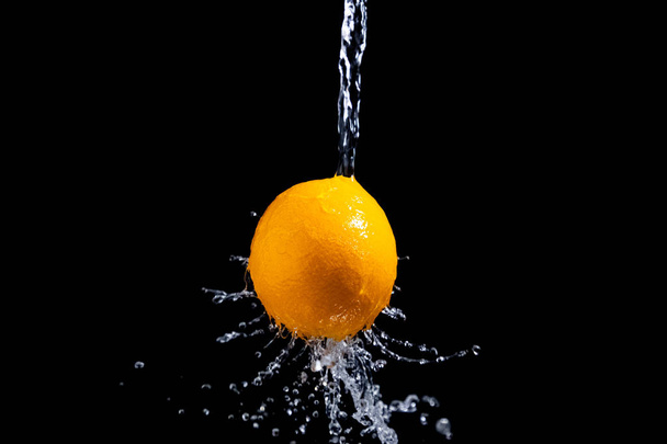 orange splash on black background - Фото, изображение