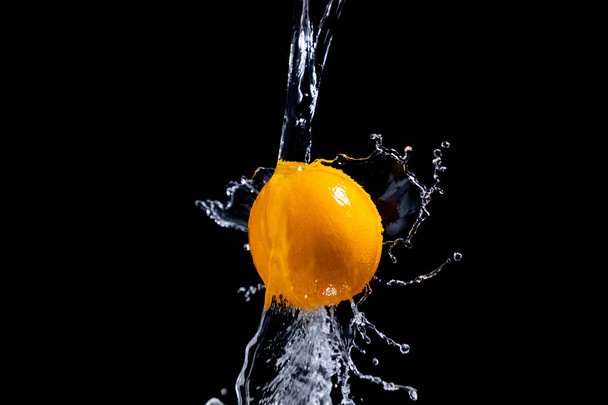 orange splash on black background - Fotoğraf, Görsel