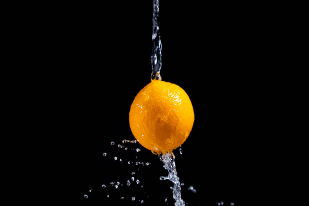 orange splash on black background - Foto, imagen