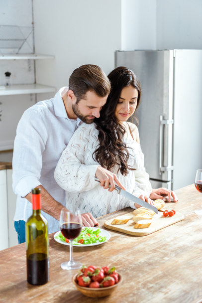 happy couple cooking dinner together at kitchen - Фото, зображення