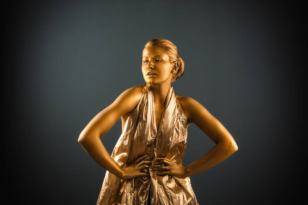 Portrait of beautiful lady with gold paint on skin against grey background - Zdjęcie, obraz