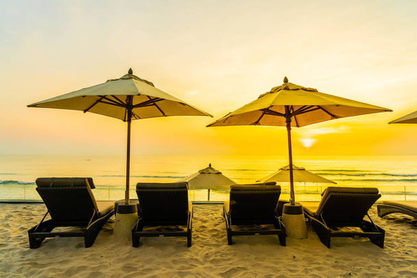 Guarda-chuva e cadeira na bela praia e mar ao nascer do sol tim
 - Foto, Imagem