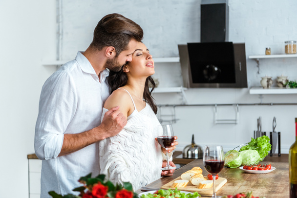 homme passionné embrassant femme joyeuse à la cuisine
 - Photo, image