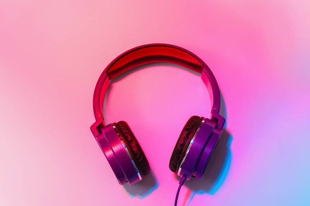 Stylish headphones on color background, top view - 写真・画像