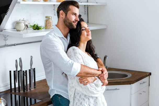 Mann umarmt glückliche Frau zu Hause sanft - Foto, Bild