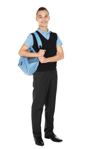 Full length portrait of teenage boy in school uniform with backpack on white background - 写真・画像