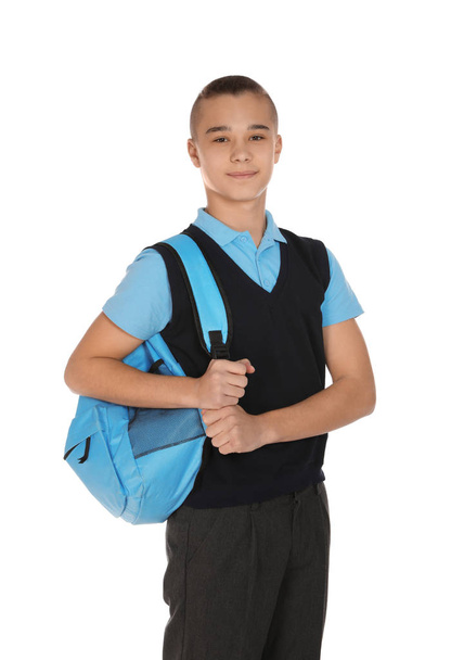 Portrait of teenage boy in school uniform with backpack on white background - 写真・画像