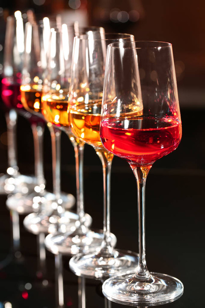 Row of glasses with different wines on table against blurred background - Φωτογραφία, εικόνα