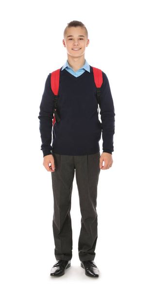 Full length portrait of teenage boy in school uniform with backpack on white background - Foto, afbeelding