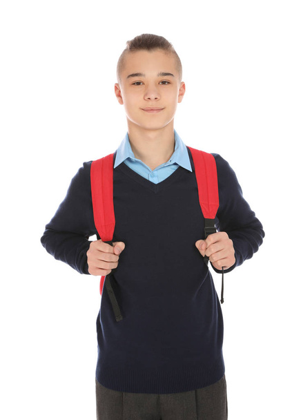 Portrait of teenage boy in school uniform with backpack on white background - Photo, image