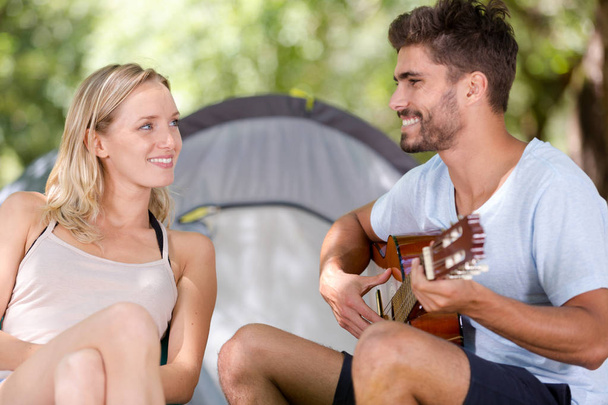 young man playing his guitar with girlfriend - Photo, Image