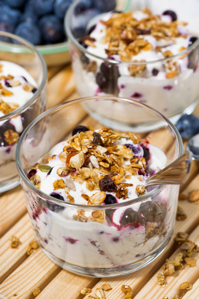 glasses with healthy dessert with blueberries, yogurt and muesli - 写真・画像