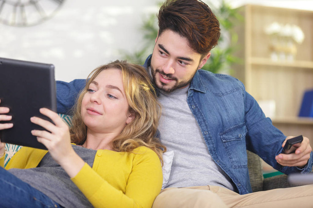 happy young couple relaxing at home with a tablet - Photo, Image