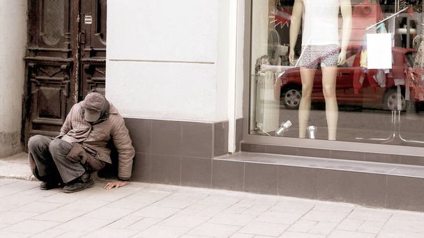 hajléktalan ember ül, az ablak, az áruház mellett - Fotó, kép