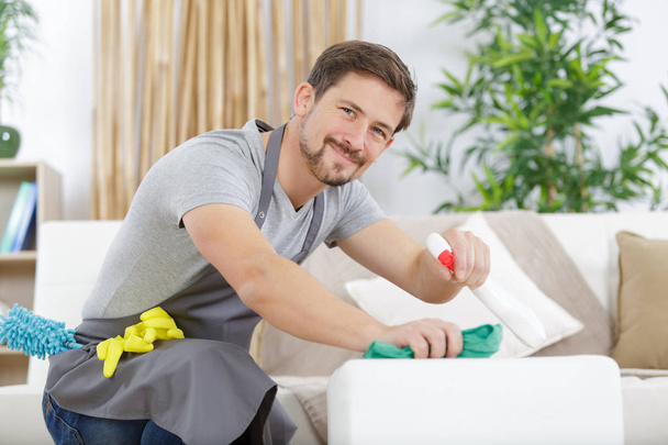 young man cleaning a sofa at home - Фото, зображення