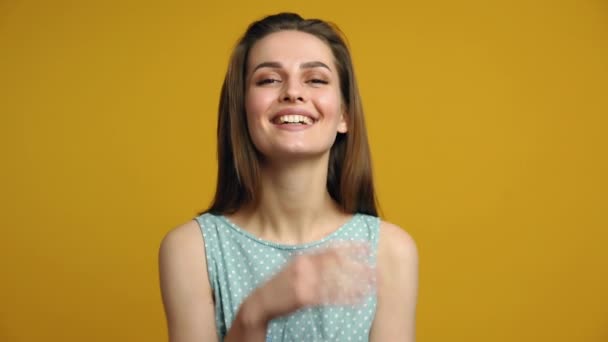 Young beautiful woman in polka dot dress posing on yellow background. Emotions concept - Záběry, video