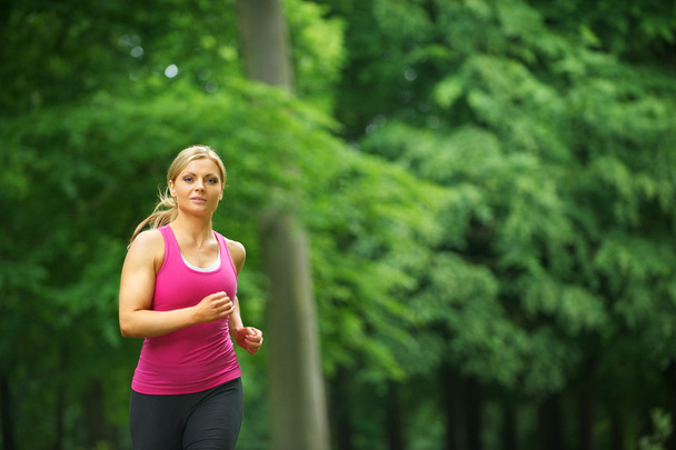 Young woman running in the park at her leisure - Photo, Image
