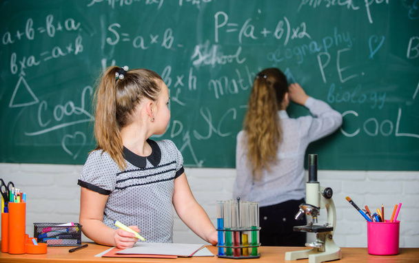 Fascinating science. Educational experiment. Girls classmates study chemistry. Microscope test tubes chemical reactions. Pupils at chalkboard chemistry lesson. Laboratory practice. Chemistry classes - Photo, Image