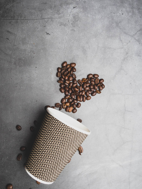 символ сердца из кофейных зерен из одноразовой бумажной чашки
 - Фото, изображение
