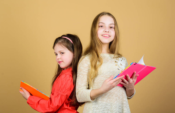 small girls with note books. Friendship and sisterhood. workbooks for writing. Back to school. students reading a book. School project. happy little children ready for school lesson. Studying hard - Foto, afbeelding