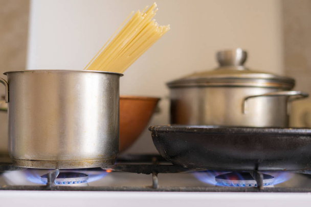 werken obrn eith brandende gas en pan met koken lekker eten in het, home cookings - Foto, afbeelding