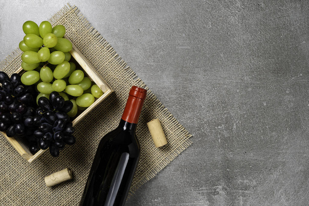 Caja de madera con cuenco de uvas con vino sobre fondo de hormigón. Copiar espacio
. - Foto, Imagen
