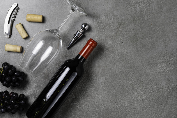 Wine bottle, glass, opener and grapes on concrete background. Copy Space. - Fotó, kép