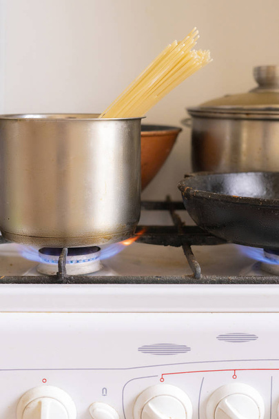 werken obrn eith brandende gas en pan met koken lekker eten in het, home cookings - Foto, afbeelding