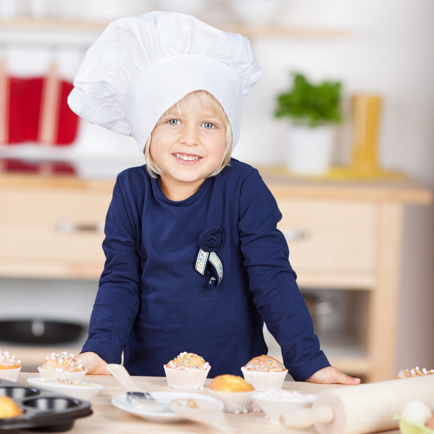Cute little blond girl in a chefs toque - Foto, Bild